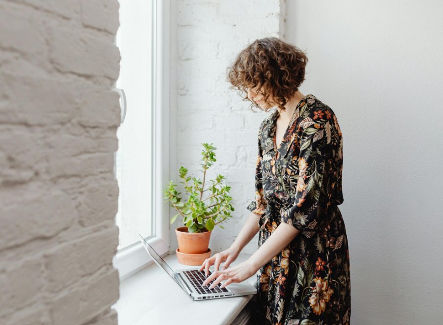Woman working at laptop by window